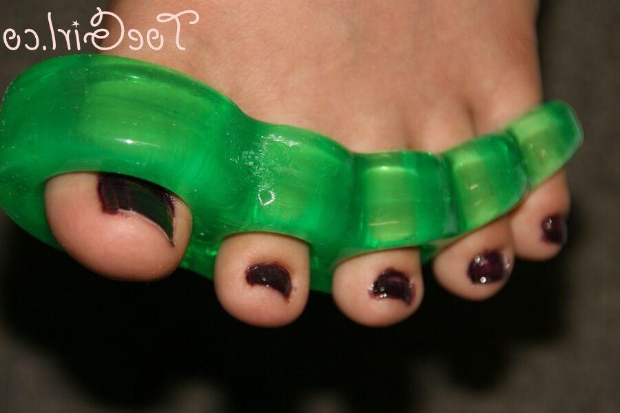16P Caucasian girl dons toe spreaders before painting her toenails