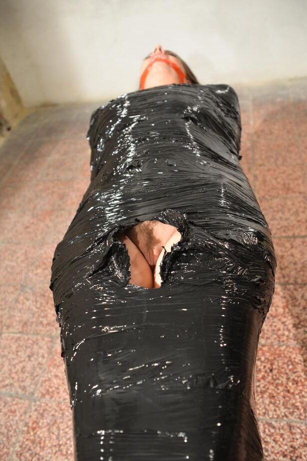15P Naked female in high heeled shoes only is mummified in plastic and gagged