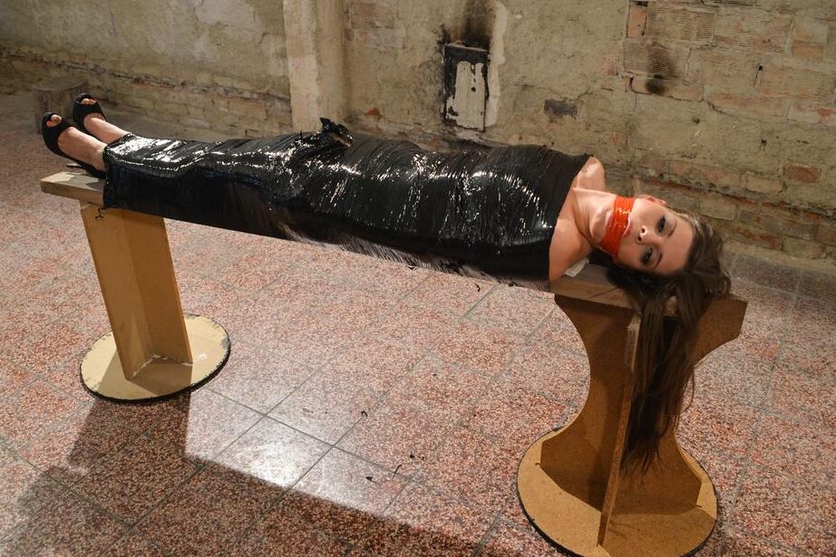 15P Naked female in high heeled shoes only is mummified in plastic and gagged