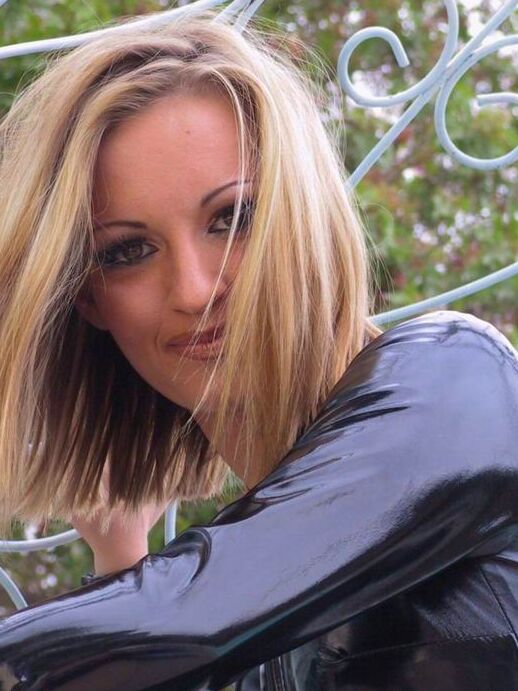 15P Solo model Jasmine Lynn unzips her latex catsuit while in a backyard
