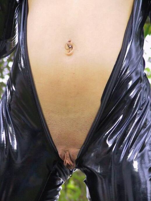15P Solo model Jasmine Lynn unzips her latex catsuit while in a backyard