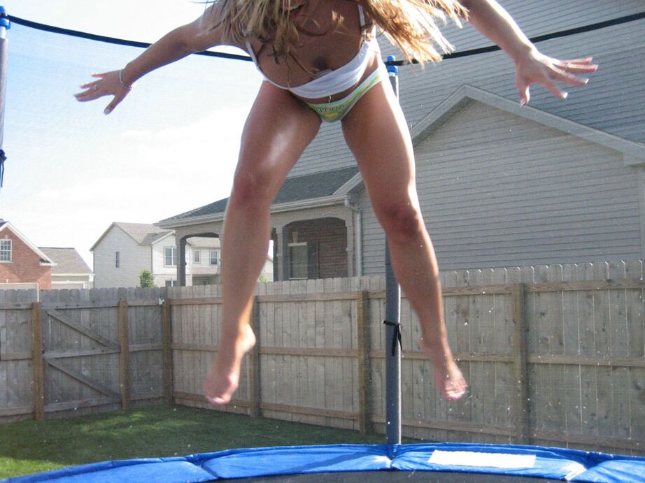 12P Chica amateur rebota en un trampolín en ropa interior y una camiseta con tirantes finos