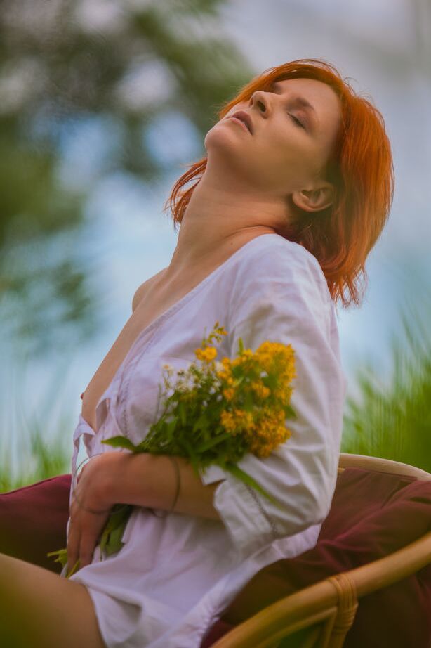 16P Natural redhead Andrea P models totally naked on a chair near the water