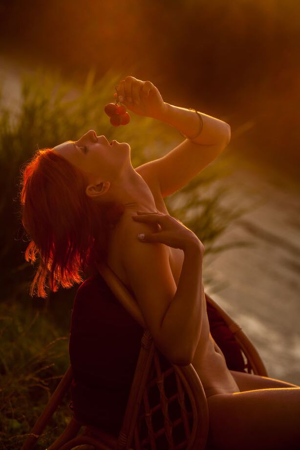 16P Natural redhead Andrea P models totally naked on a chair near the water
