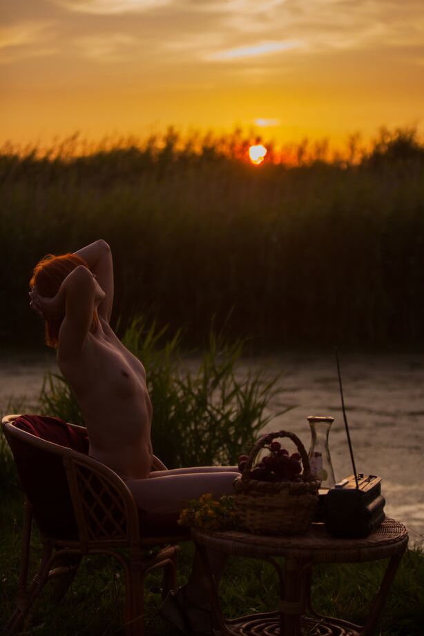 16P Natural redhead Andrea P models totally naked on a chair near the water