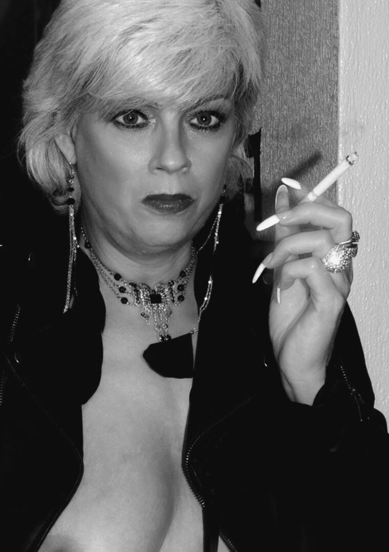 16P Une blonde plus âgée allume une cigarette tout en montrant ses seins nus et sa chatte