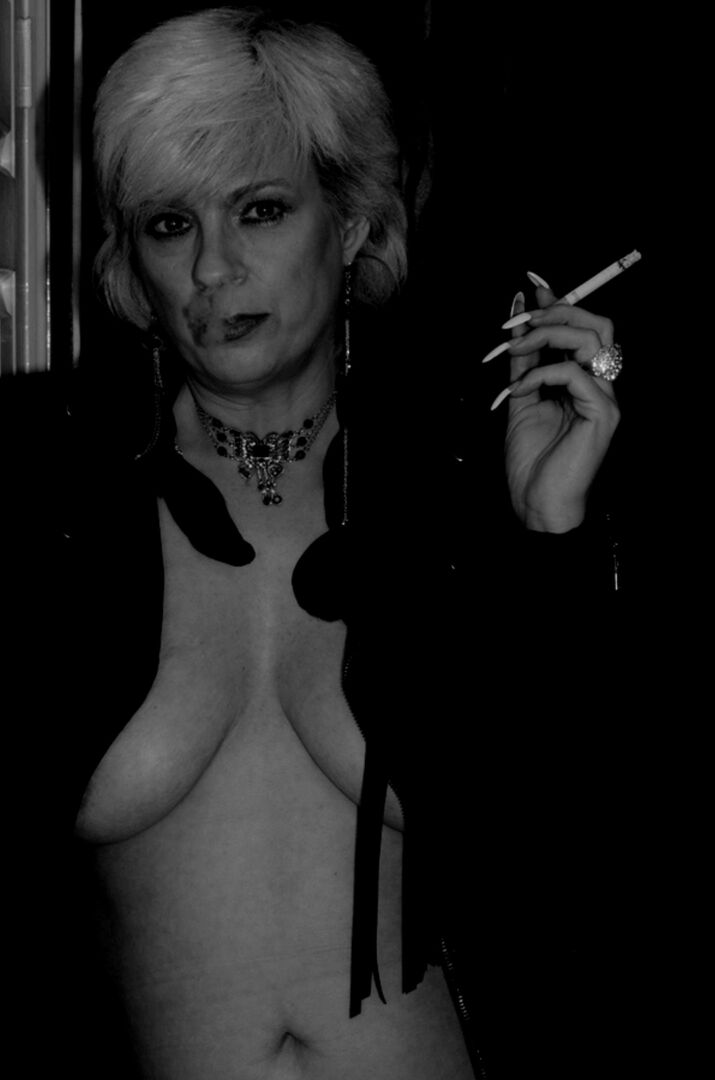 16P Une blonde plus âgée allume une cigarette tout en montrant ses seins nus et sa chatte