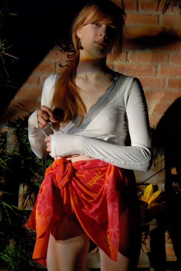 16P Lina, rousse naturelle, expose ses sous-vêtements en jupe haute dans un jardin.