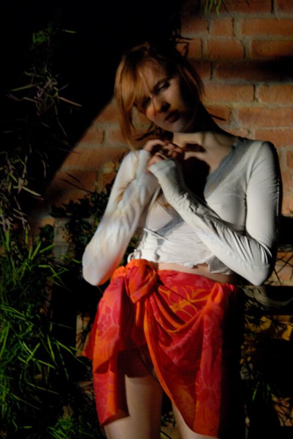 16P Lina, rousse naturelle, expose ses sous-vêtements en jupe haute dans un jardin.