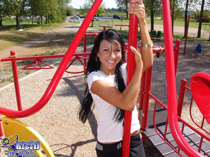 12P Dark-haired girl Trista Stevens frolics around a playground in a bikini