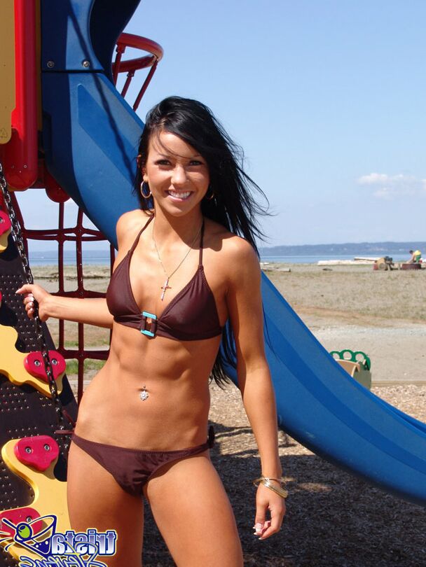 12P Dark-haired girl Trista Stevens frolics around a playground in a bikini