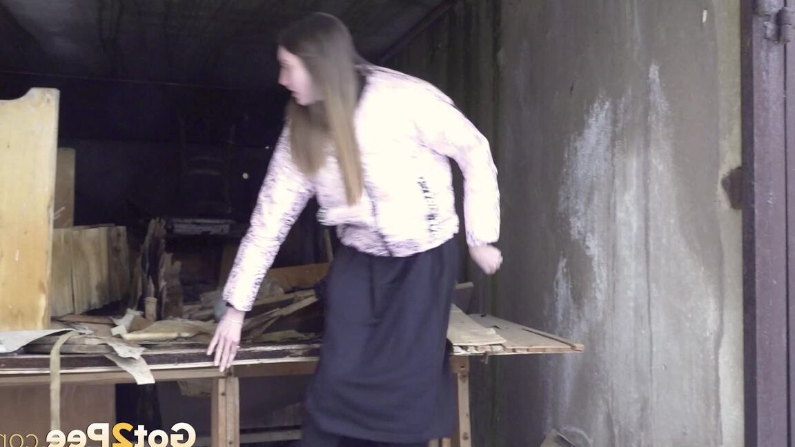 15P Distressed girl takes a piss on a table in an abandoned building