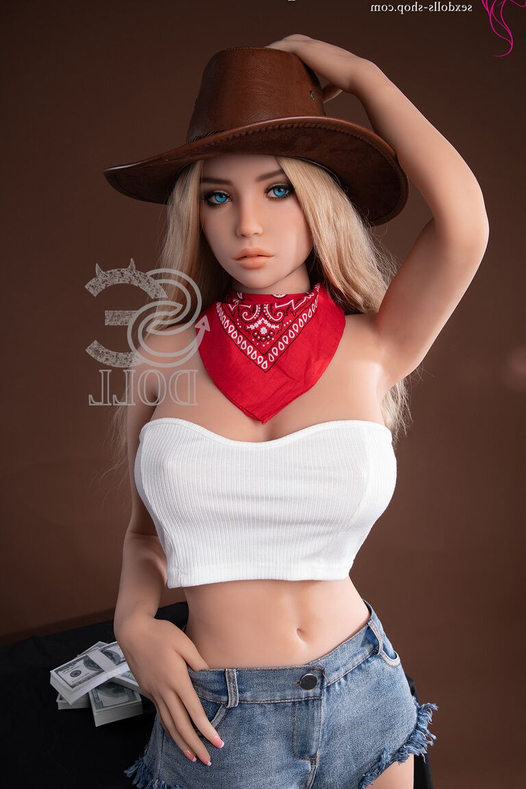 Caroline, poupée sexuelle cowgirl 21P, se déshabille et enfile ses bottes noires.