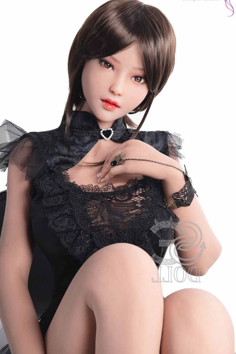 21P Une poupée sexuelle brune dans une robe noire chaude montre sa chatte et ses gros seins