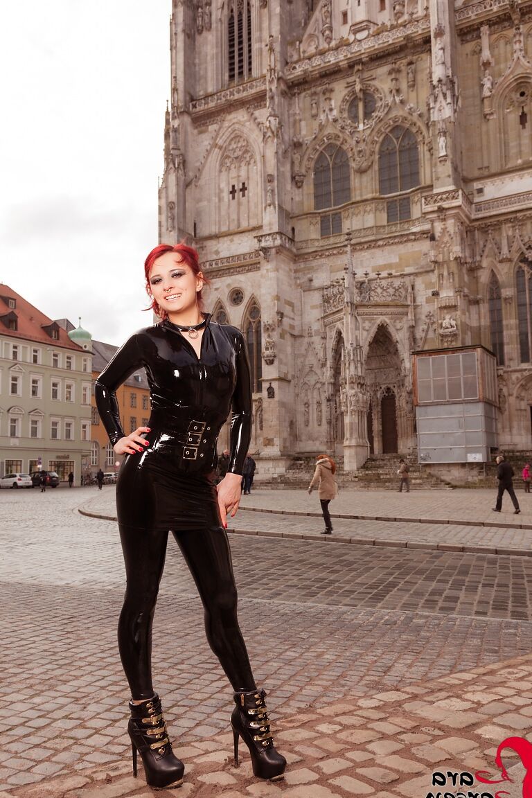 12P Sexy redhead Lara Larsen models on a city street in latex clothing and boots