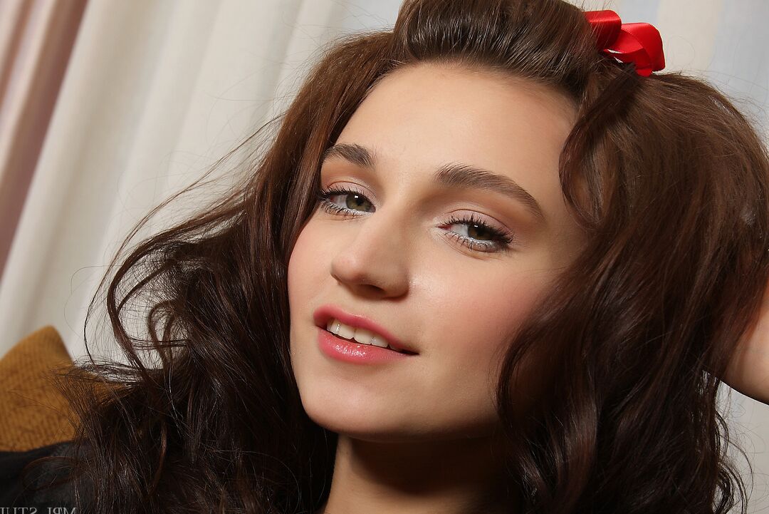 12P Brunette glamour model poses in the nude with a red bow in her hair