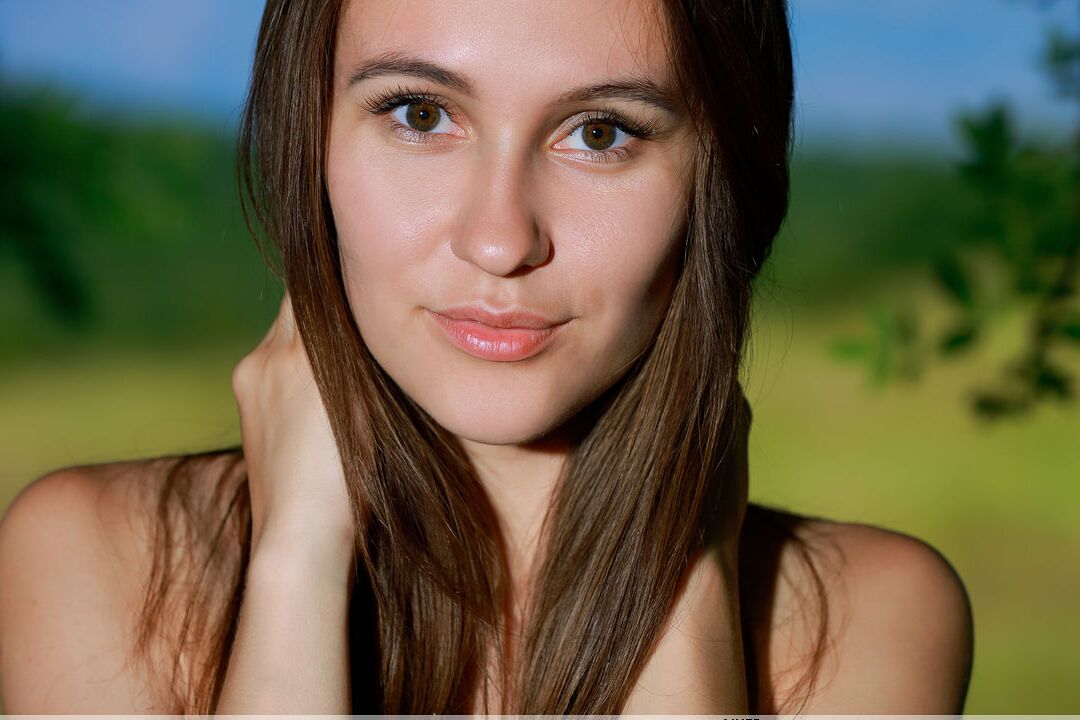 16P Leggy teen Belisa G peels off tight pants to pose nude by trees in a field