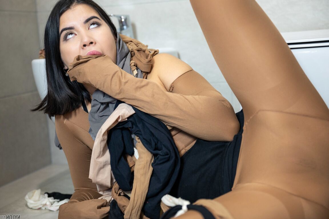 16P Dark-haired beauty Lady Dee encases herself in pantyhose while in a bathroom