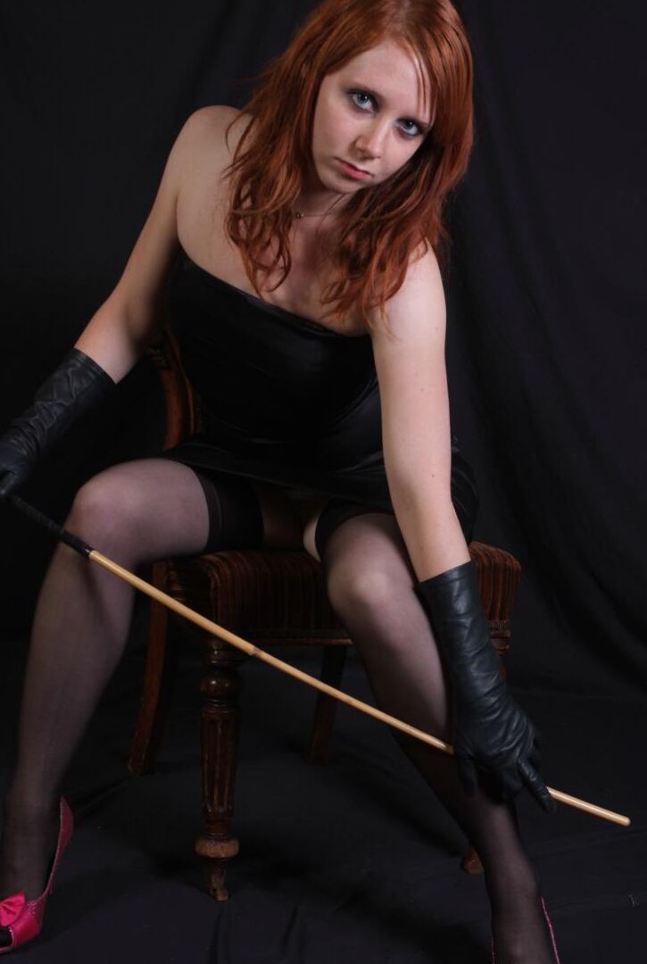 15P Une rousse sexy fléchit une canne avant de toucher sa fente serrée avec des gants en cuir