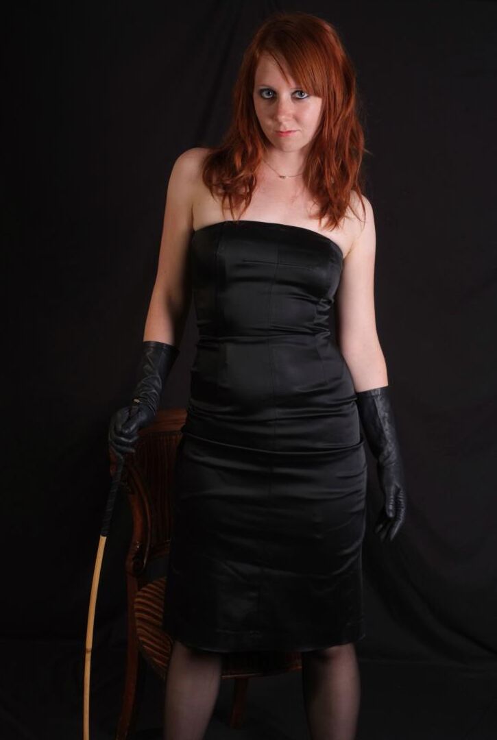 15P Une rousse sexy fléchit une canne avant de toucher sa fente serrée avec des gants en cuir