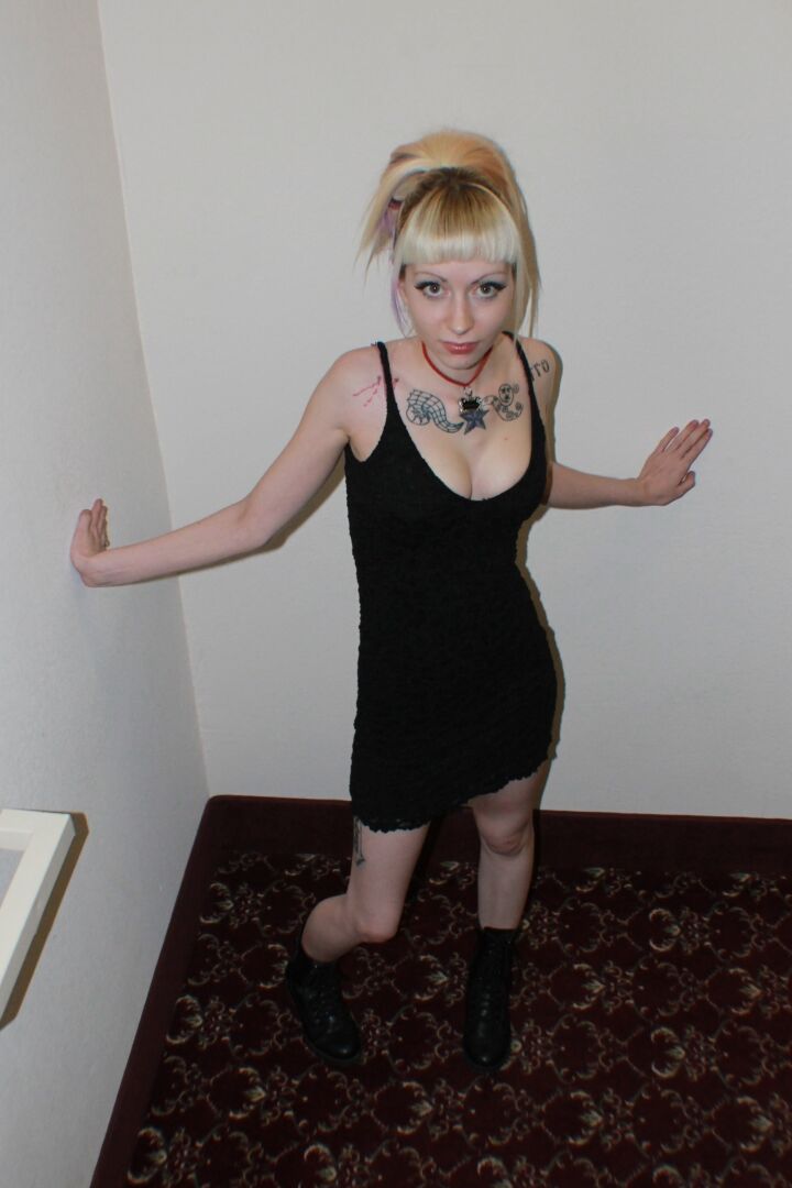 21P La rubia tatuada Symone haciendo alarde de sus piernas sexys con un vestido negro corto