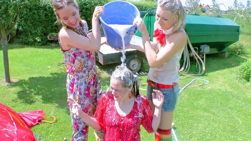 14P Young girls soak each other in a backyard while washing a compact vehicle