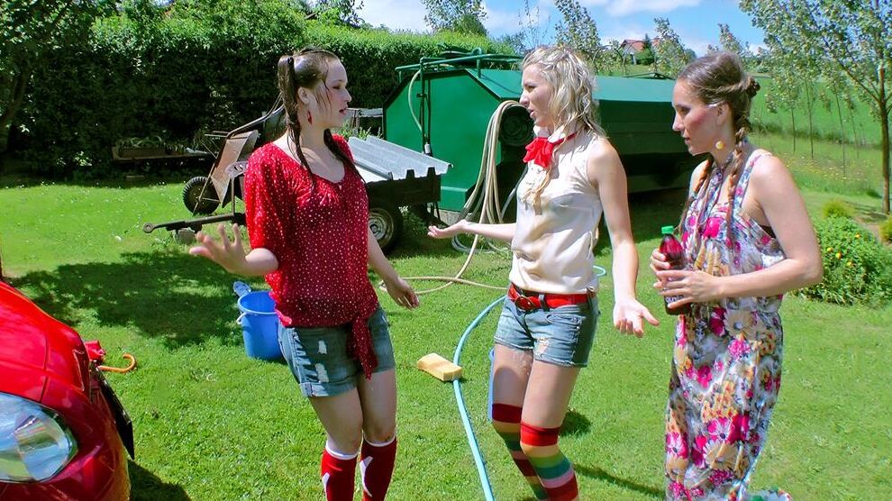 14P Young girls soak each other in a backyard while washing a compact vehicle