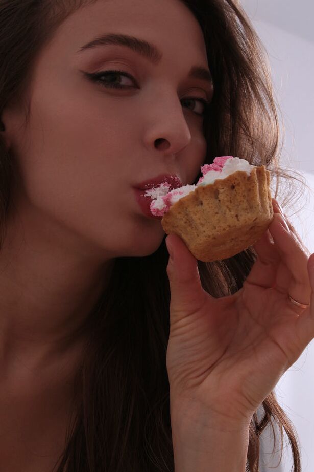 18P Santa enjoys her baked cupcake, playing with the creamy frosting on her lips