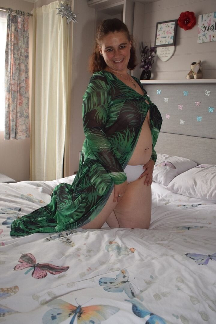 16P Grosse femme s'expose sur un lit en portant une robe longue