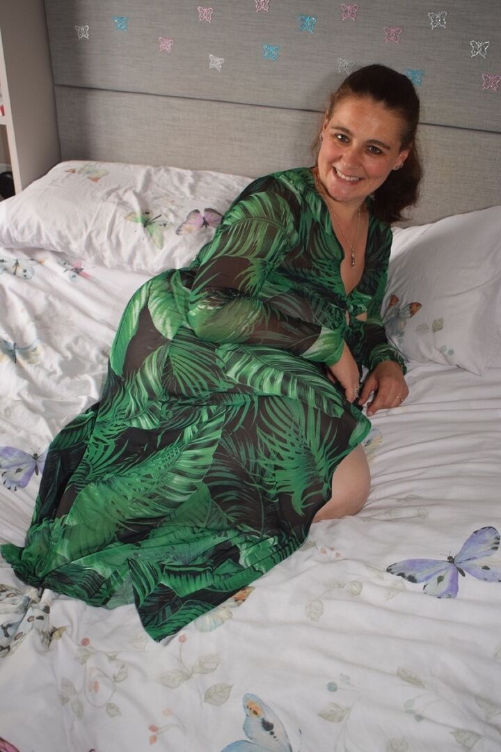 16P Grosse femme s'expose sur un lit en portant une robe longue