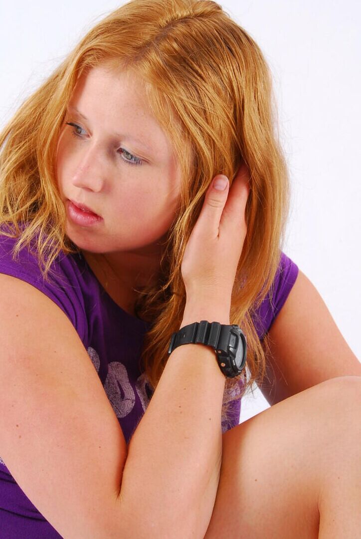 Die 16P natürliche Rothaarige Judy modelliert eine schwarze G-Shock-Uhr, während sie vollständig bekleidet ist