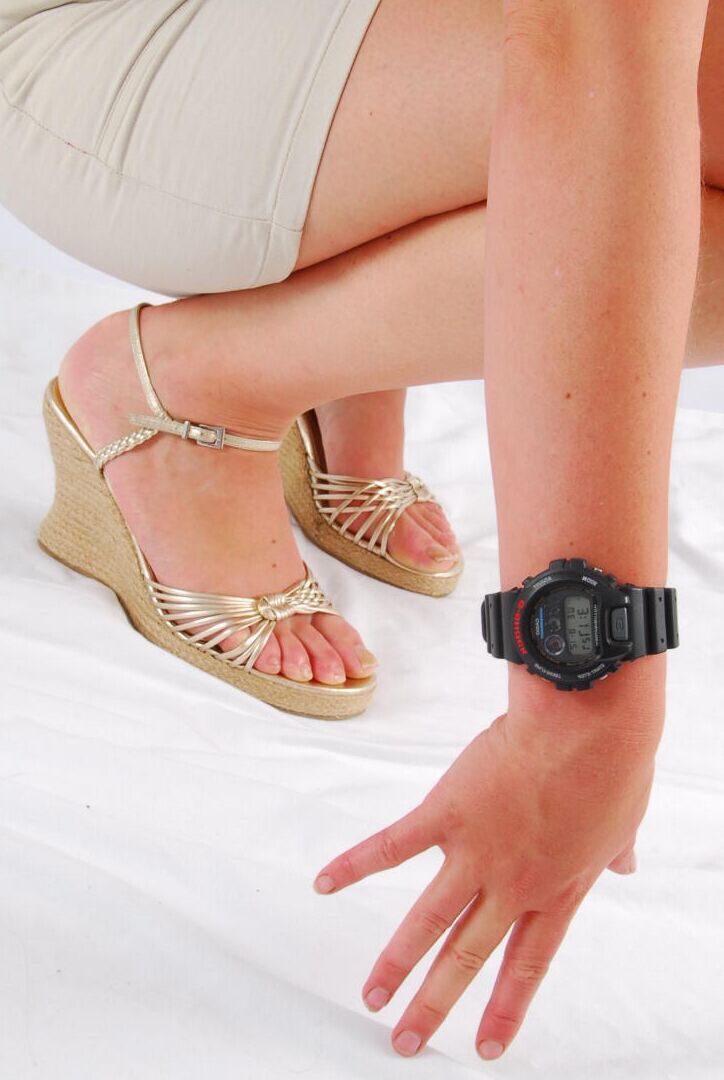Die 16P natürliche Rothaarige Judy modelliert eine schwarze G-Shock-Uhr, während sie vollständig bekleidet ist