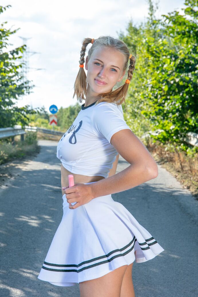 20P Die blonde Teenagerin Nana zieht sich auf einer gepflasterten Straße bis auf ihre Socken und Laufschuhe aus
