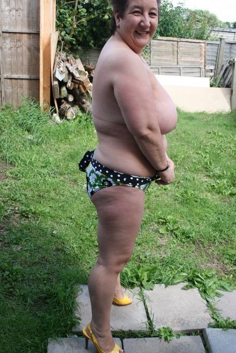 16P La gorda madura Kinky Carol resalta su gran culo mientras se desnuda en un jardín