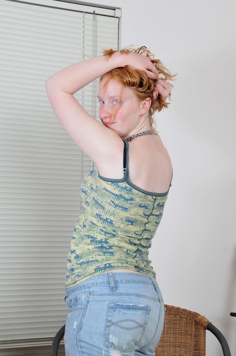 21P Sandy, une adolescente amateur, se déshabille et doigte son manchon en fourrure alors qu'elle est assise sur un tapis.