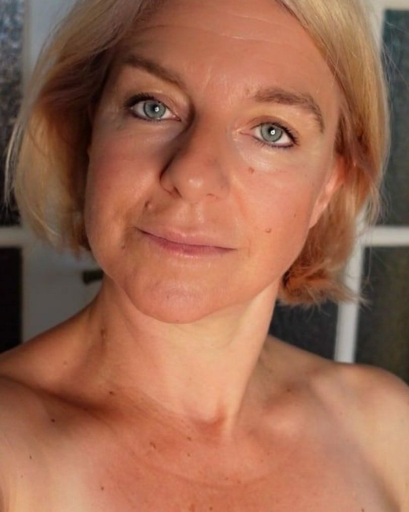 11P Blauäugige reife Blondine stellt ihren heißen, kurvigen Körper zur Schau, während sie im Fenster posiert