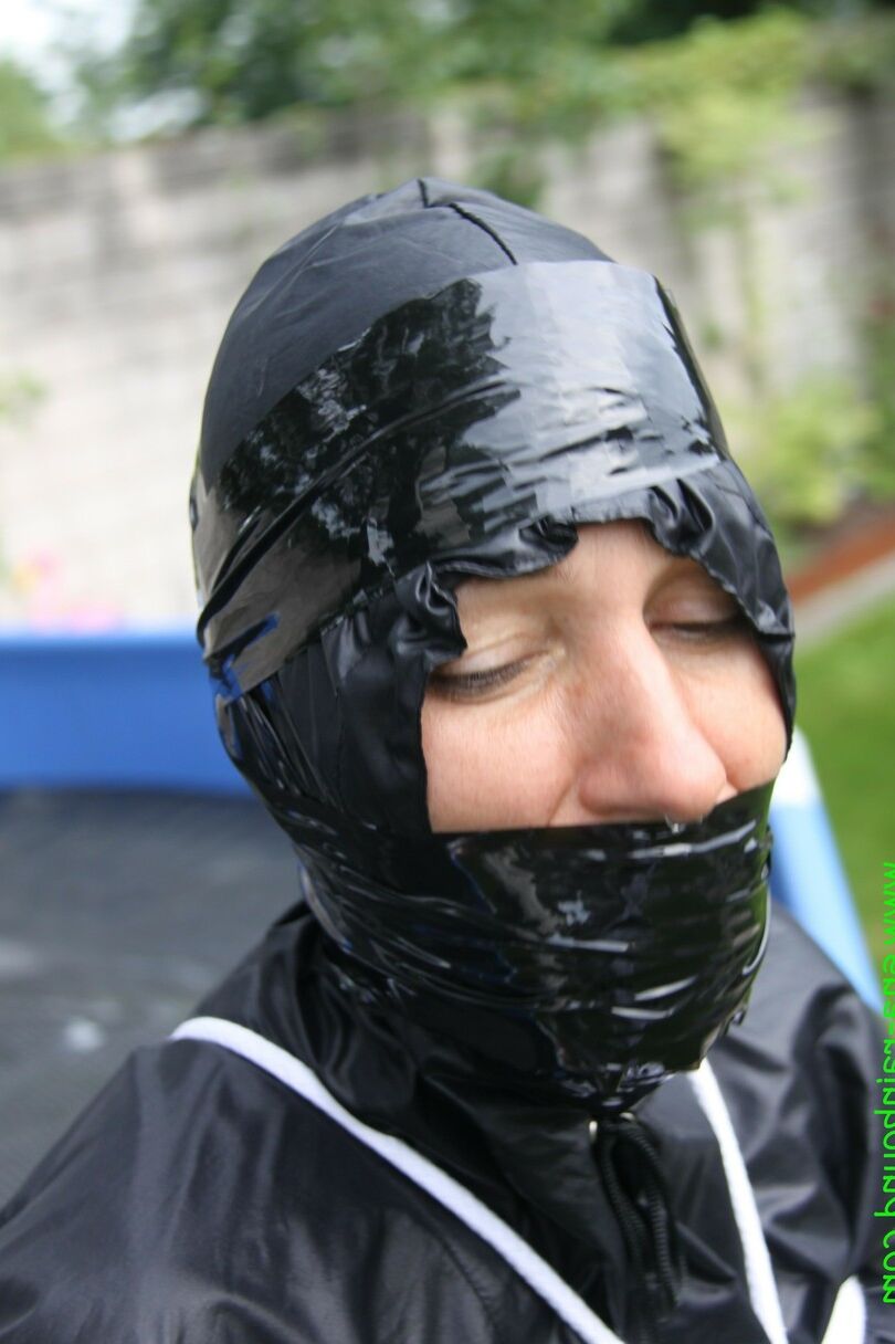 16 Photos La femme amateur Sandra est bâillonnée et attachée à une piscine dans un imperméable