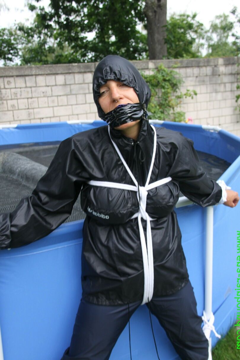 16 Photos La femme amateur Sandra est bâillonnée et attachée à une piscine dans un imperméable