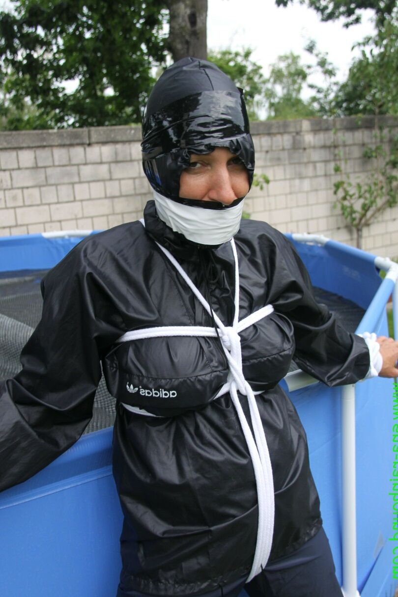 16 Photos La femme amateur Sandra est bâillonnée et attachée à une piscine dans un imperméable