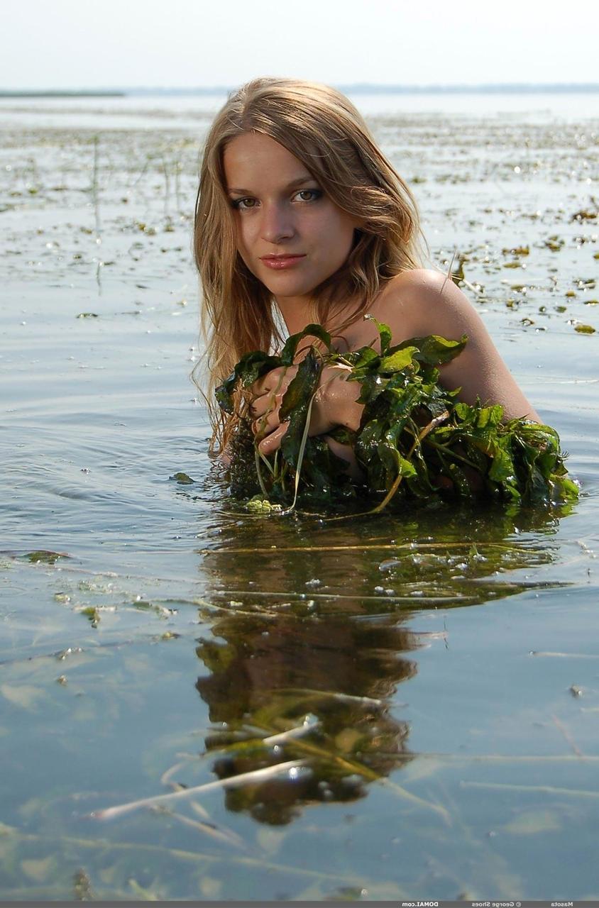 20P Masota, une jolie fille aux seins naturels, taquine avec son corps nu et mouillé dans une rivière.
