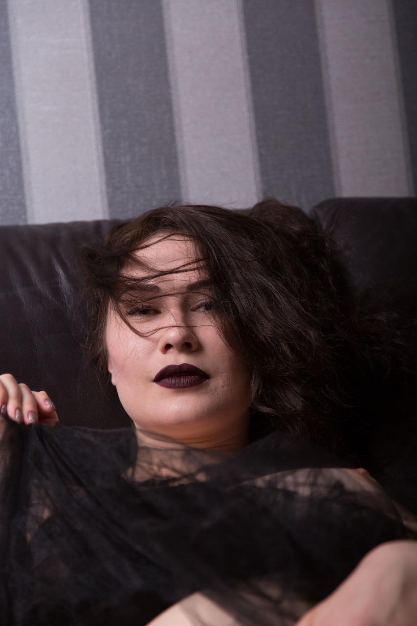 17P La brune aux gros seins Judith Able enlève son bandeau et ses bas sur la causeuse.