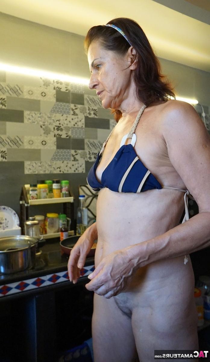 16P Diana Ananta, une femme mûre, prépare un repas tout en portant un bikini.