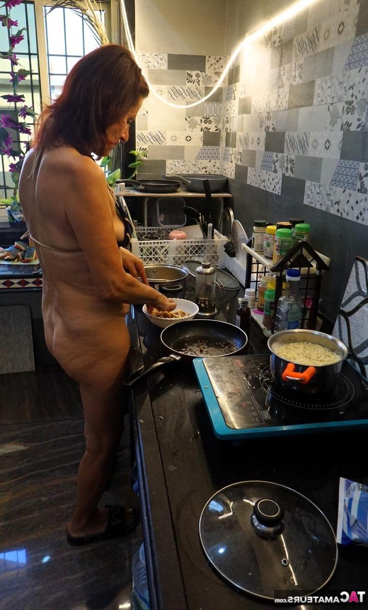 16P Diana Ananta, une femme mûre, prépare un repas tout en portant un bikini.
