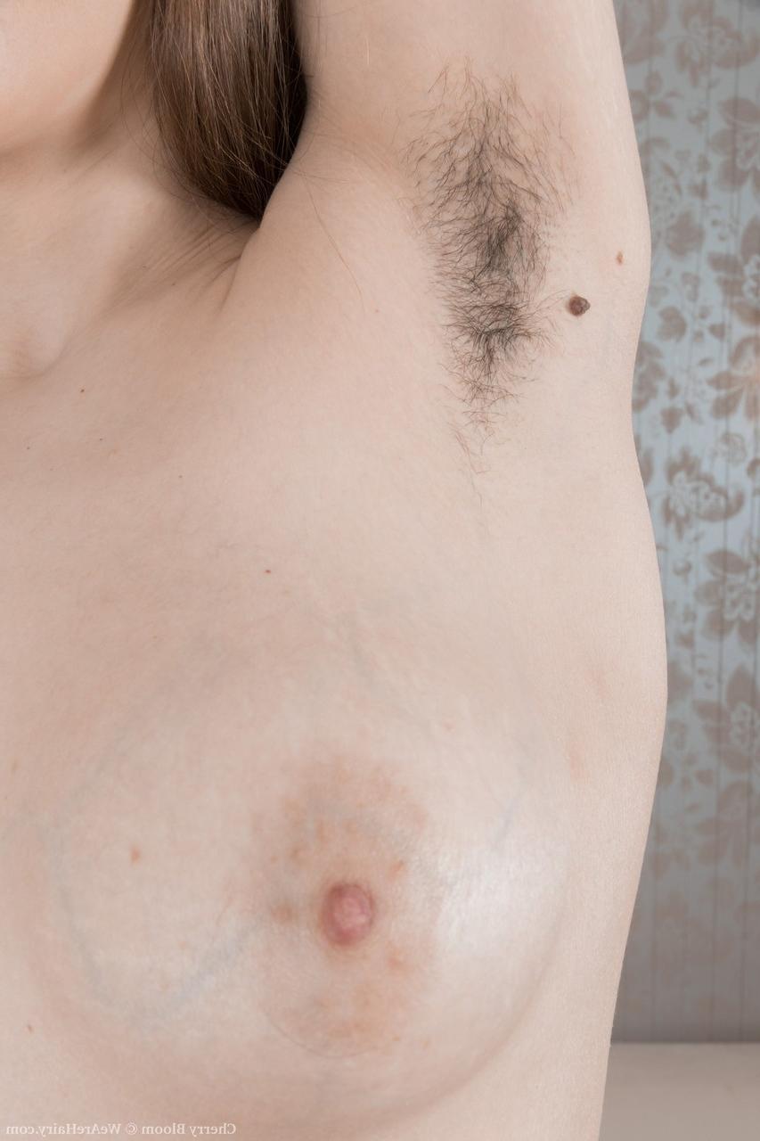 20P La jeune flexible Cherry Bloom se met nue pour exhiber et doigter sa chatte touffue.