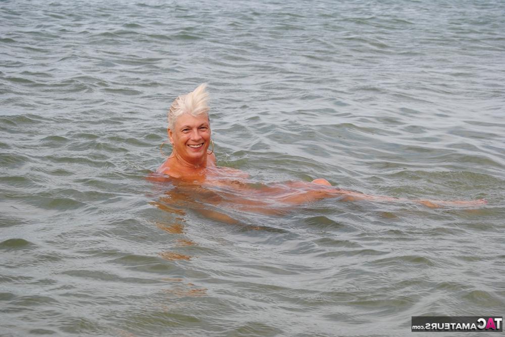 20P Abuela madura dimonty bañándose desnuda en la playa con grandes tetas caídas colgando