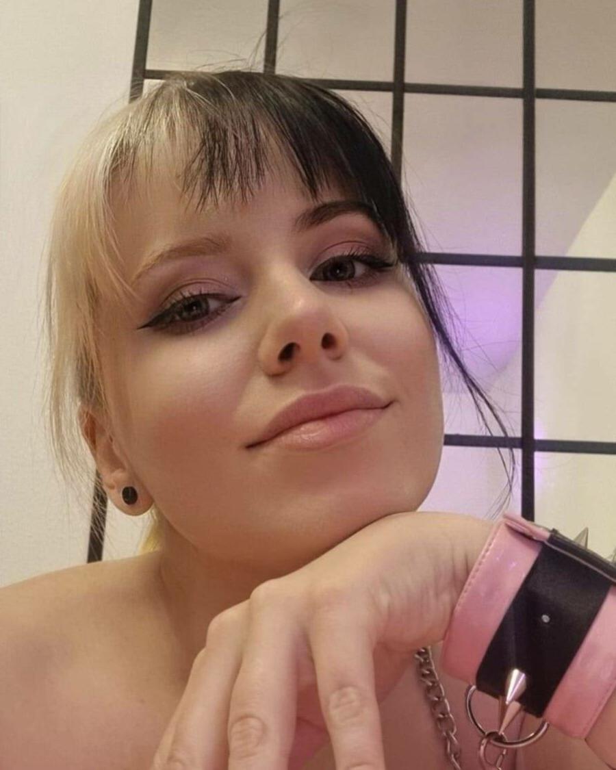 20P Kira Jameson, amatrice sexy, pose en solo dans sa robe et ses talons en latex rose.
