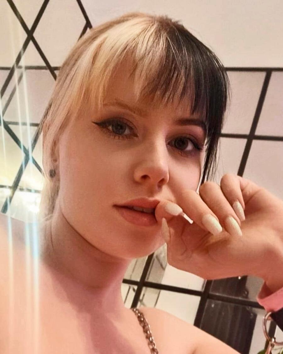 20P Kira Jameson, amatrice sexy, pose en solo dans sa robe et ses talons en latex rose.