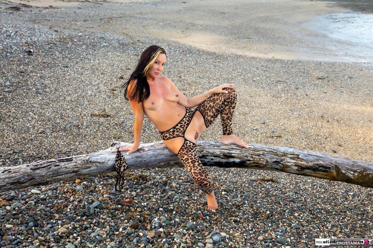 16P La sexy MILF Roxeanne se desnuda sobre madera flotante con medias con estampado animal