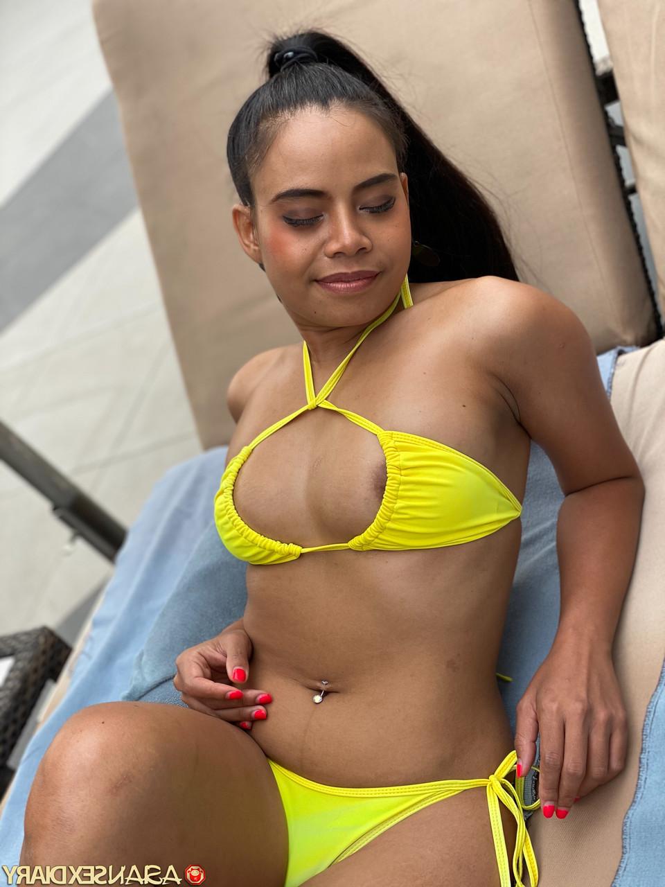 20P Cute Latina Barbie C flaunts her curves wearing a yellow bikini poolside