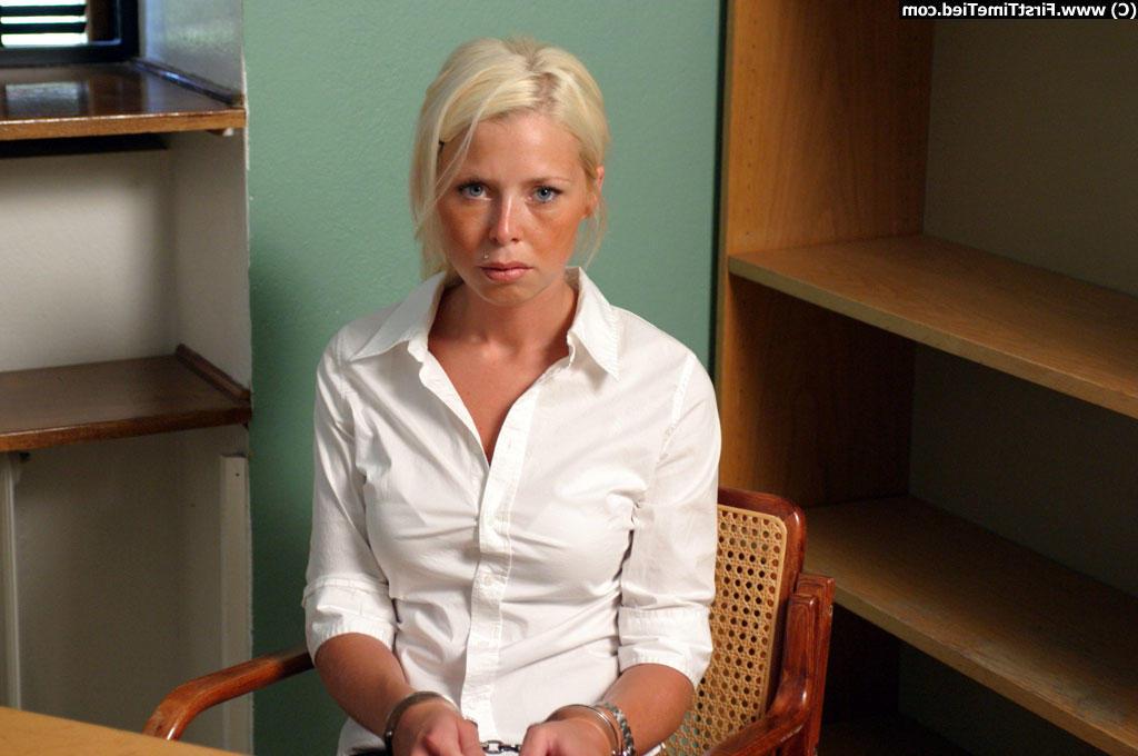 12P Une fille blonde vêtue d'une jupe noire et d'un chemisier blanc est menottée